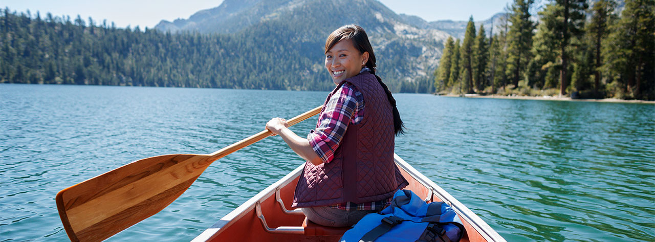 Woman paddling a canoe on a lake
