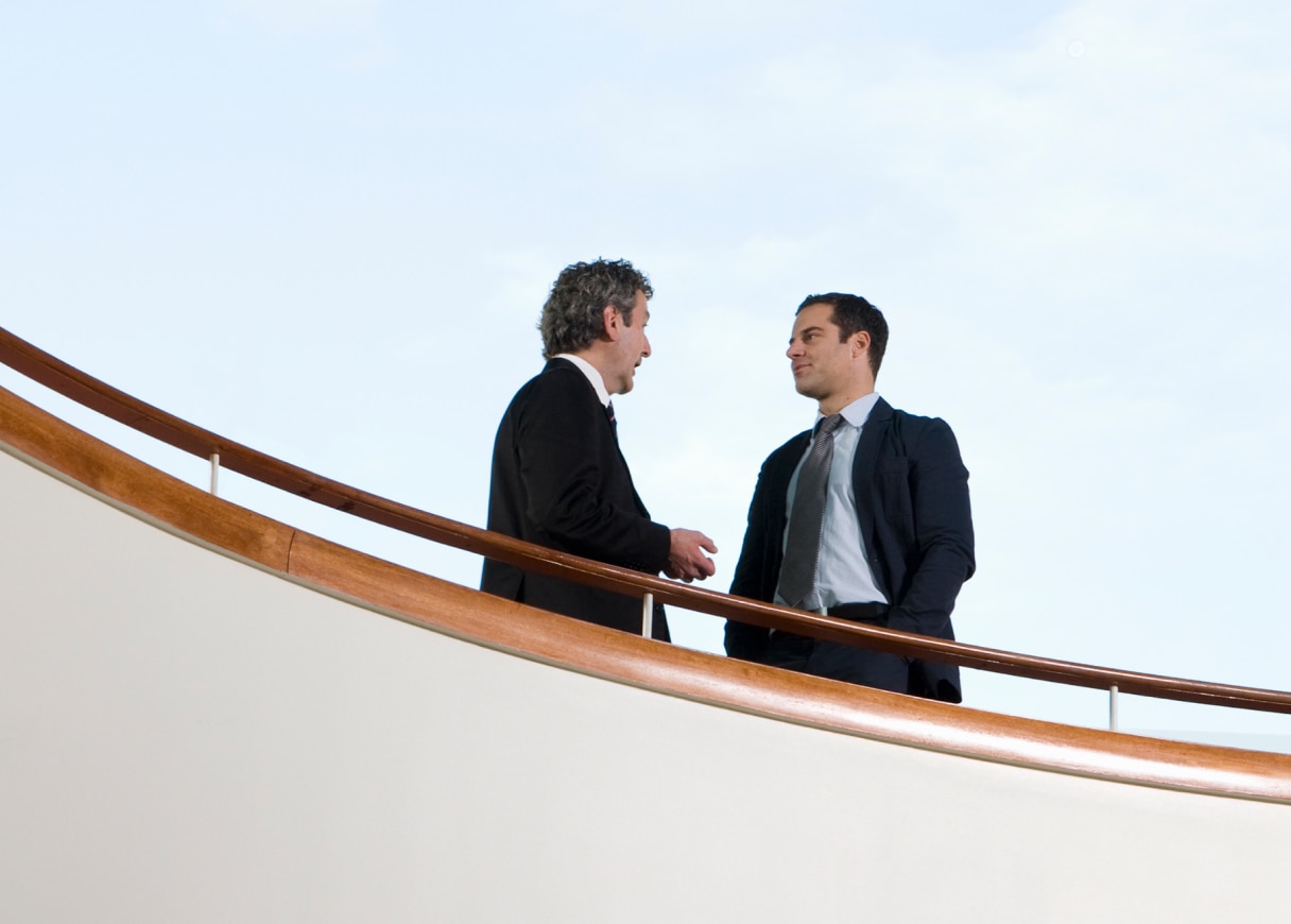 Two men talking near stairs